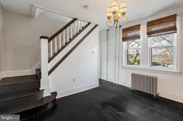 a view of a hallway with wooden floor and a kitchen