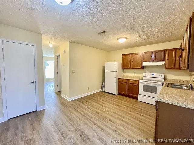 a kitchen with a refrigerator and a stove top oven