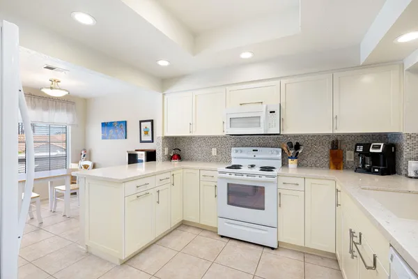 a kitchen with white cabinets appliances and sink