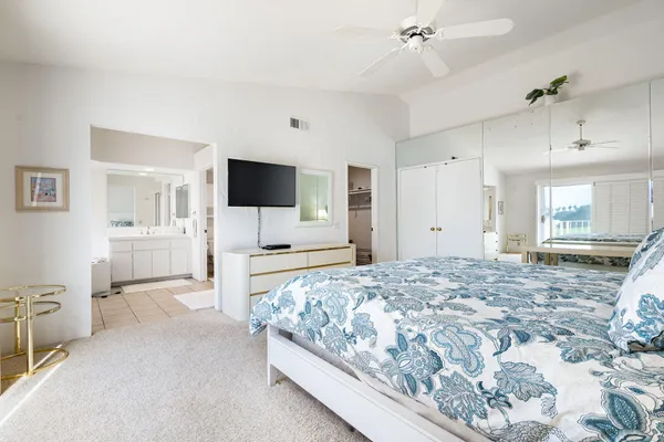 a spacious bedroom with a bed and a flat screen tv