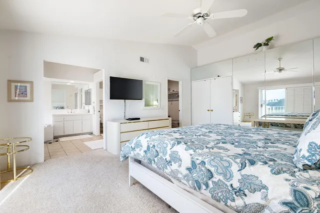 a spacious bedroom with a bed and a flat screen tv