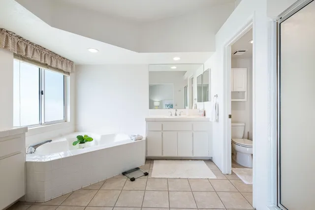 a bathroom with a bathtub a sink and a mirror