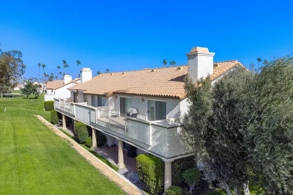 a view of a house with roof deck and a yard