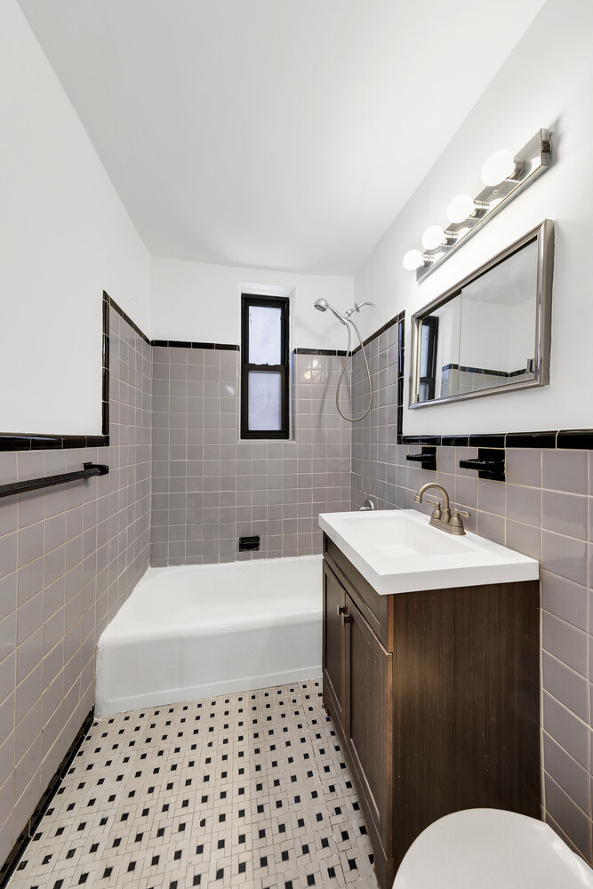 100 Bank Street, Unit 2B Manhattan, NY 10014 - Photo 7 of 9 a bathroom with a sink a toilet a mirror and shower