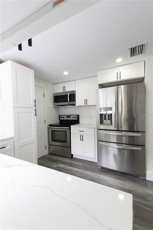 6340 Westport Drive Port Richey, FL 34668 - Photo 13 of 51 a kitchen with stainless steel appliances a refrigerator stove and microwave