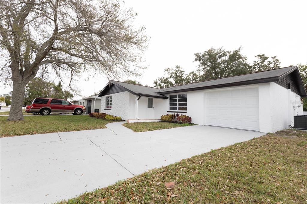 6340 Westport Drive Port Richey, FL 34668 - Photo 7 of 51 a front view of a house with a yard and garage