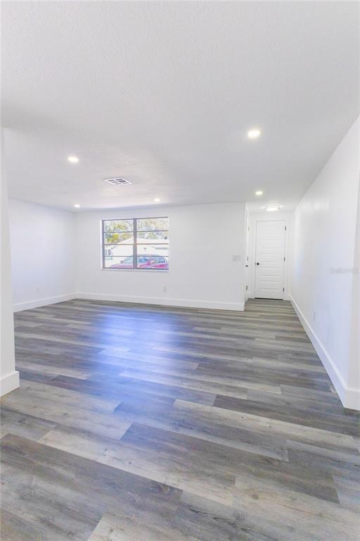 6340 Westport Drive Port Richey, FL 34668 - Photo 9 of 51 a view of an empty room with wooden floor and a window