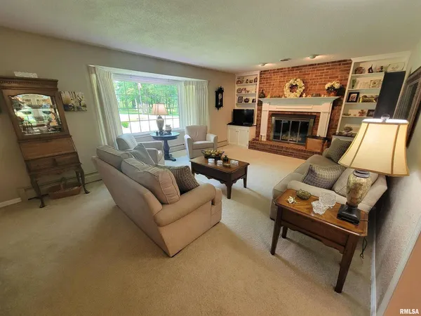 a kitchen with stainless steel appliances kitchen island granite countertop a table chairs and a refrigerator