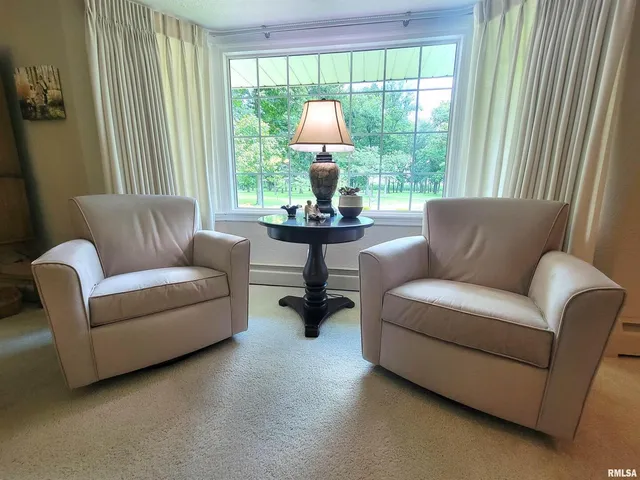 a kitchen with stainless steel appliances granite countertop a refrigerator a sink dishwasher a stove and a dining table with wooden floor