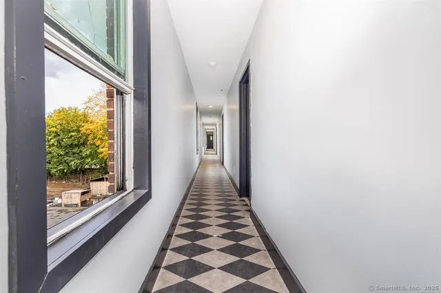 a view of a hallway with wooden floor and a large window