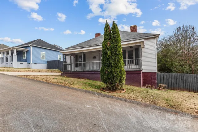 a view of a house with a yard and large tree