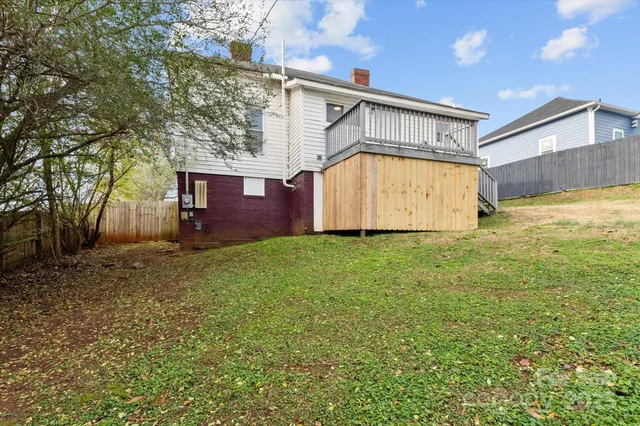 a view of a big house with wooden fence
