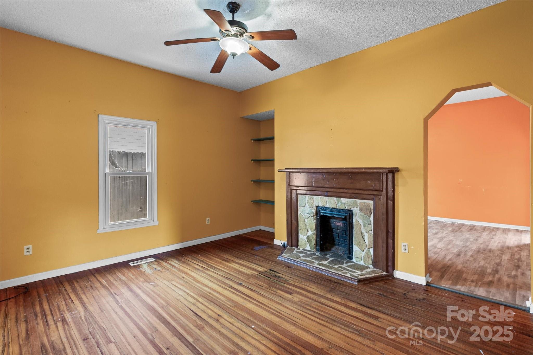 30 2nd Street Cramerton, NC 28032 - Photo 6 of 21 a view of an empty room with wooden floor and a fireplace