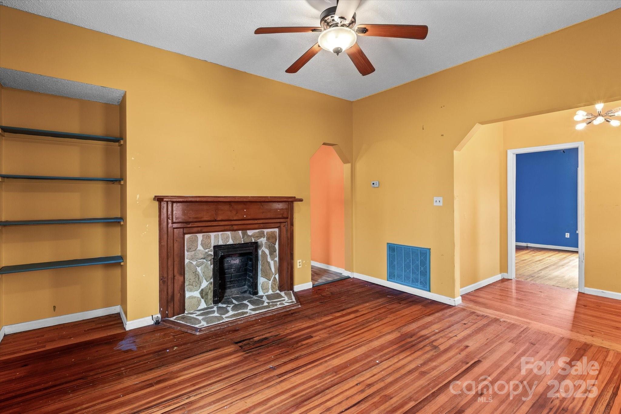 30 2nd Street Cramerton, NC 28032 - Photo 7 of 21 a view of an empty room with wooden floor and a fireplace