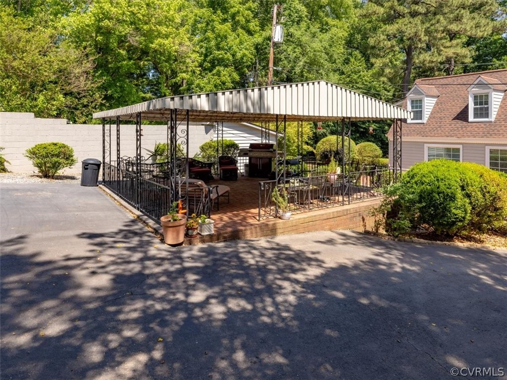 4610 Butte Road Richmond, VA 23235 - Photo 44 of 48 a view of a patio with a table and chairs under an umbrella with large trees