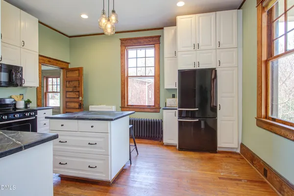 a kitchen with a refrigerator and a stove top oven