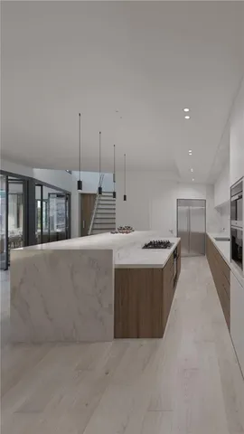 a large kitchen with kitchen island a large counter top a sink a stove and a refrigerator