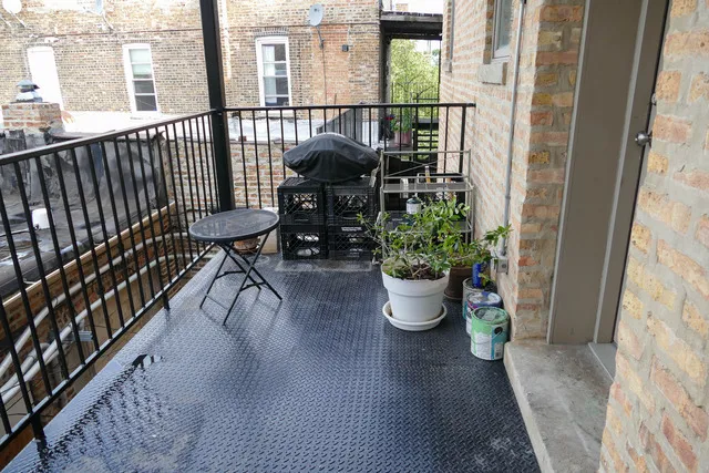 a view of a balcony with chairs and potted plants