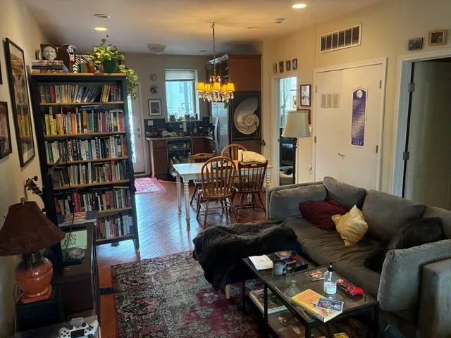 a living room with furniture and a book shelf