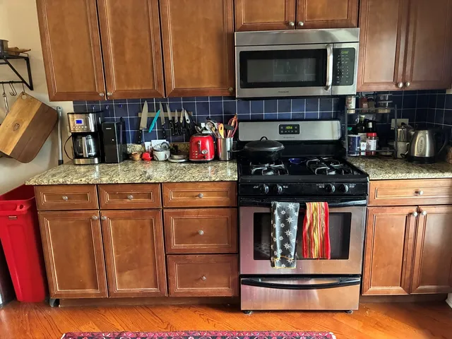 a kitchen with stainless steel appliances granite countertop a stove and cabinets