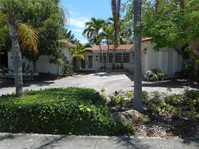 a backyard of a house with a garden and palm trees