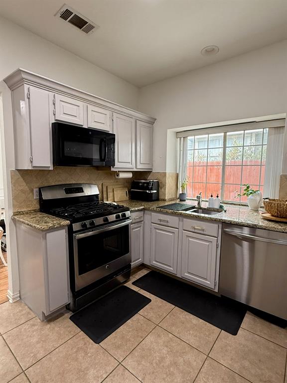 417 Moonlight Way Irving, TX 75063 - Photo 8 of 31 a large kitchen with granite countertop a stove a sink and a microwave