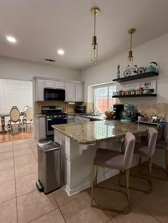 a kitchen with stainless steel appliances granite countertop a sink a stove top oven a counter space and cabinets