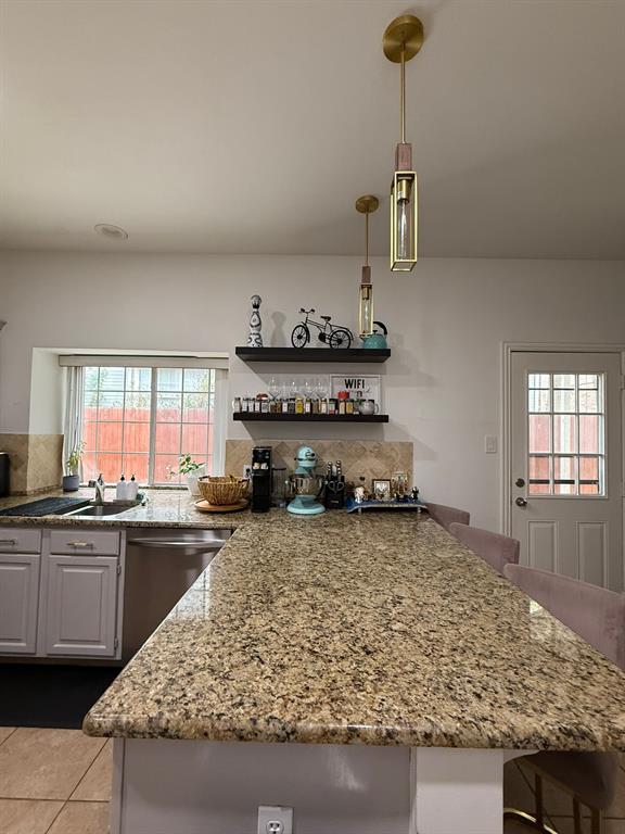 417 Moonlight Way Irving, TX 75063 - Photo 10 of 31 a kitchen with kitchen island granite countertop a sink a counter top space and cabinets