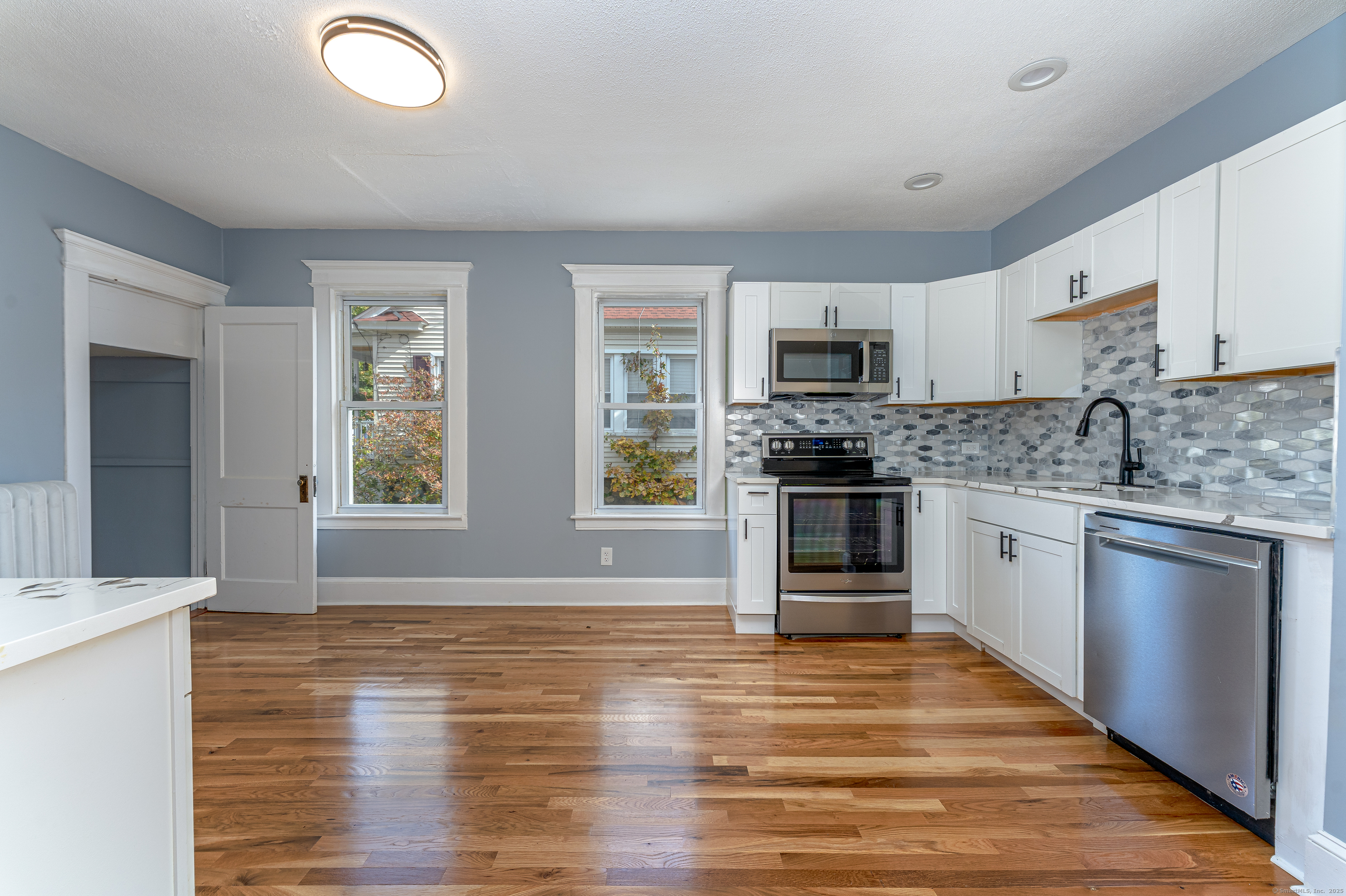 100 Ridgefield Avenue Waterbury, CT 06705 - Photo 11 of 35 a kitchen with granite countertop a stove top oven a sink dishwasher and a refrigerator with wooden floor