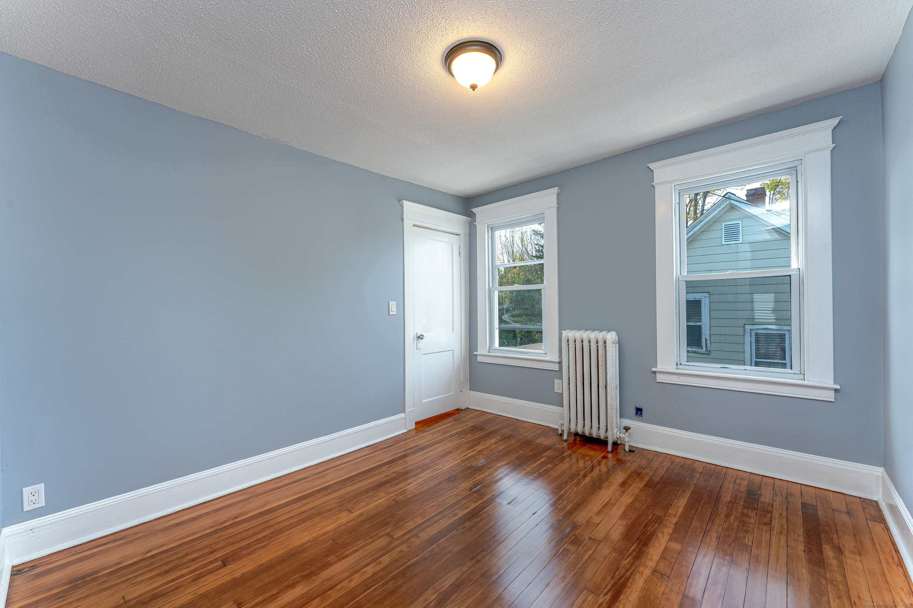 100 Ridgefield Avenue Waterbury, CT 06705 - Photo 21 of 35 an empty room with wooden floor and windows