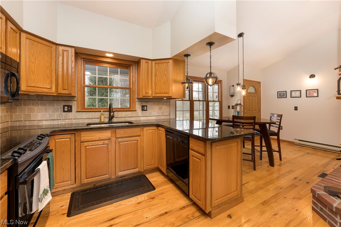 5659 State Rte 5 Ravenna, OH 44266 - Photo 6 of 48 Kitchen with baseboard heating, sink, hanging light fixtures, light wood-type flooring, and black appliances