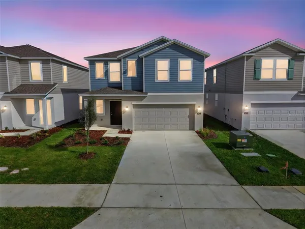 a front view of a house with yard and green space
