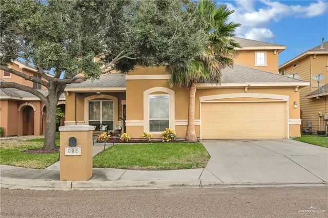 a front view of a house with a garden and garage