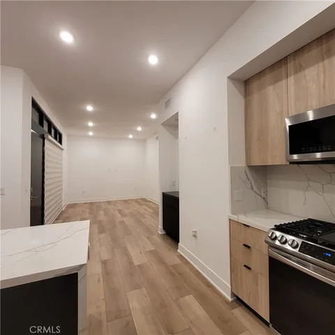 a kitchen with stainless steel appliances kitchen island granite countertop a stove a sink and a microwave