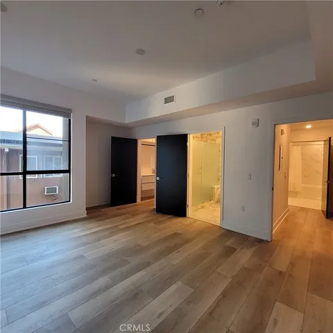 a view of an empty room with closet and a window