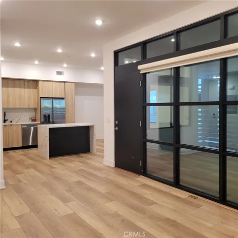a view of kitchen with stainless steel appliances kitchen island granite countertop a refrigerator and a sink