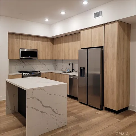 a kitchen with stainless steel appliances a refrigerator stove a sink and a microwave