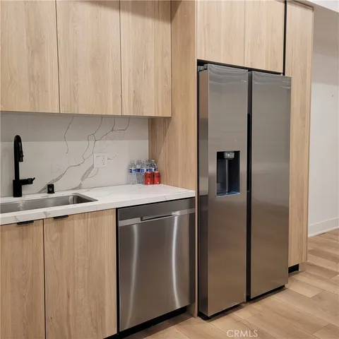 a kitchen with stainless steel appliances a refrigerator and a sink