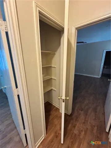 a view of a hallway with wooden floor and entryway