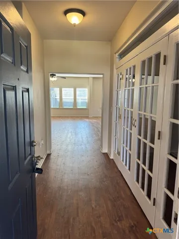 a view of a hallway with wooden floor and staircase