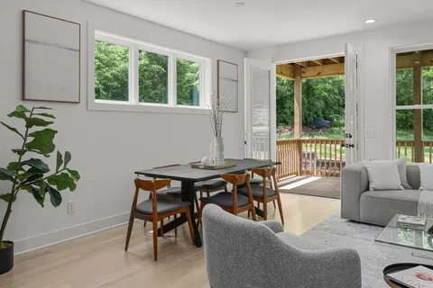 a kitchen with a stove a sink a refrigerator and chairs