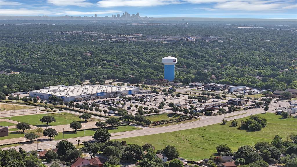 9519 County View Road Dallas, TX 75249 - Photo 30 of 31 Expansive aerial highlighting a commercial district with retail storefronts, a large parking area, and surrounding green spaces