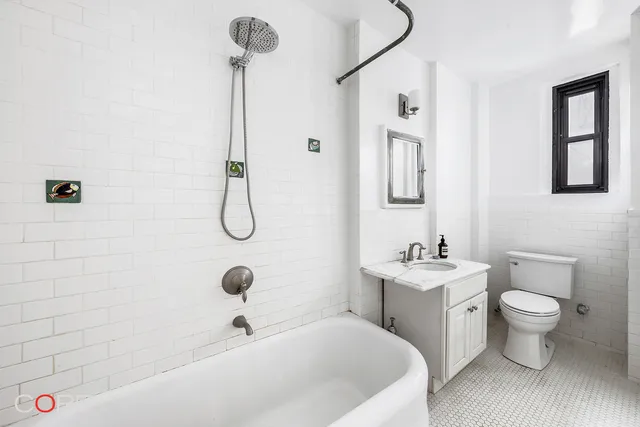 a bedroom with a bed a dresser next to a window