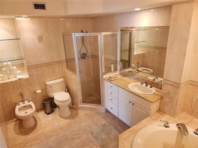 a bathroom with a granite countertop toilet sink and mirror