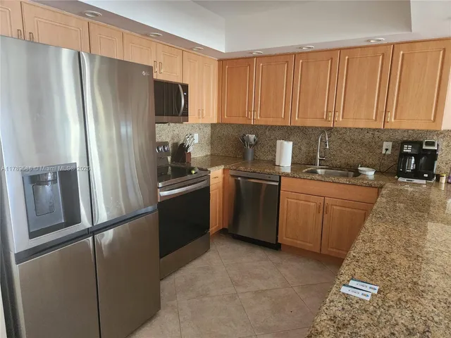 a kitchen with a refrigerator sink and cabinets
