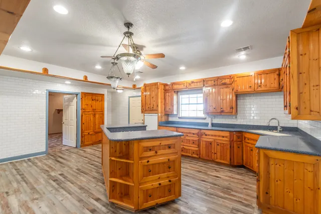 a kitchen with stainless steel appliances granite countertop a sink a stove and refrigerator