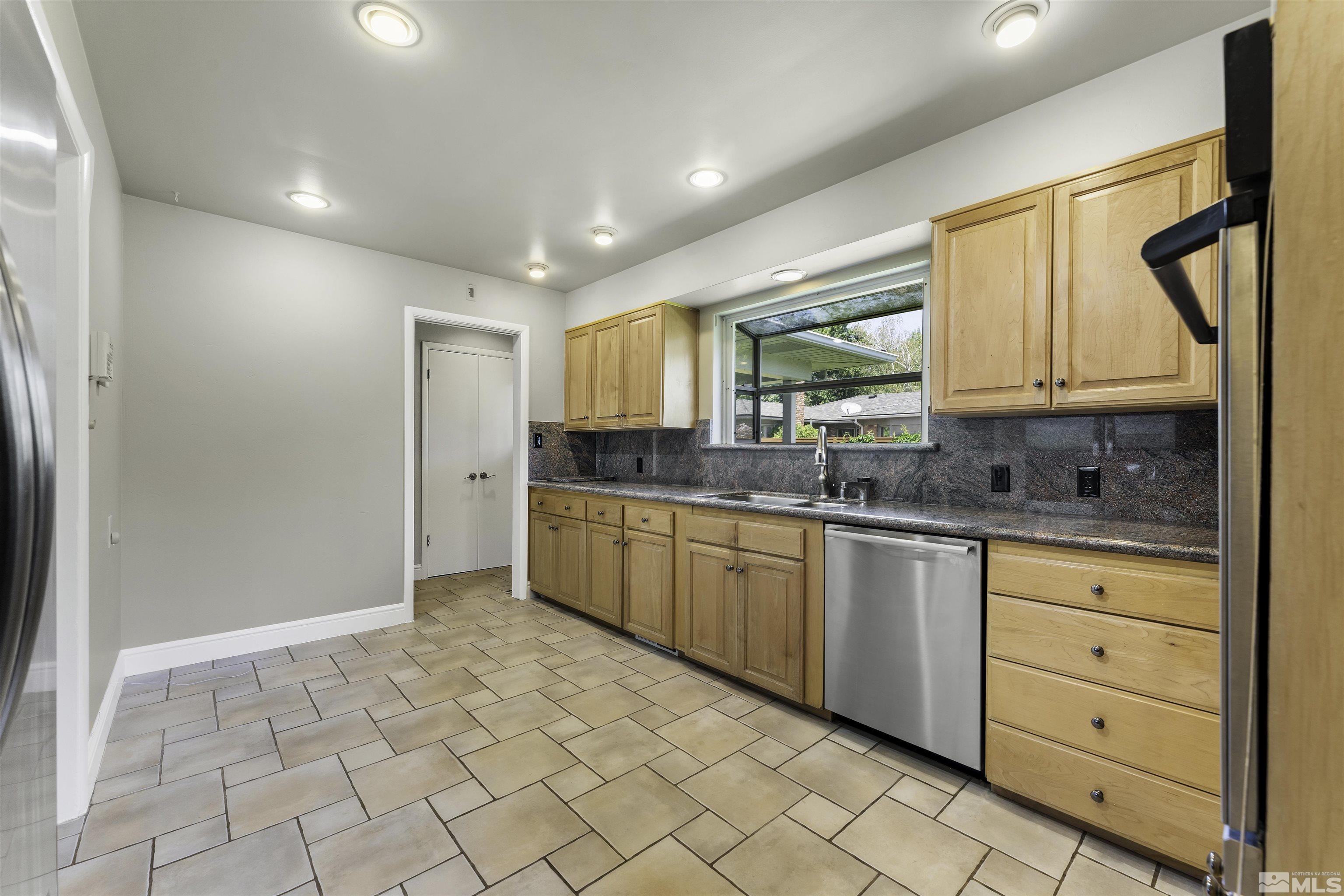 1401 Romero Way Reno, NV 89509 - Photo 12 of 28 a kitchen with granite countertop a sink window and cabinets