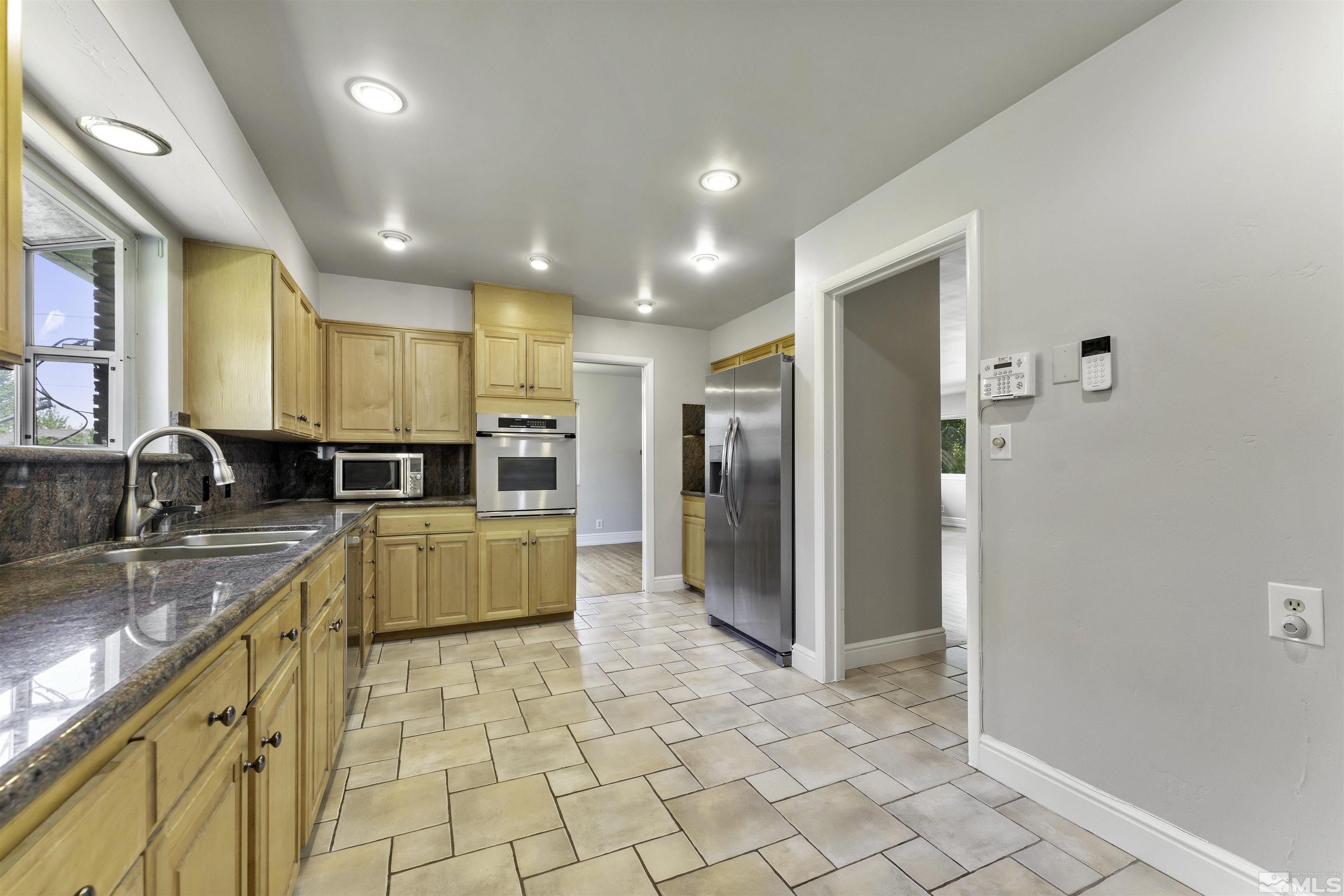 1401 Romero Way Reno, NV 89509 - Photo 13 of 28 a large kitchen with stainless steel appliances granite countertop a refrigerator and a sink