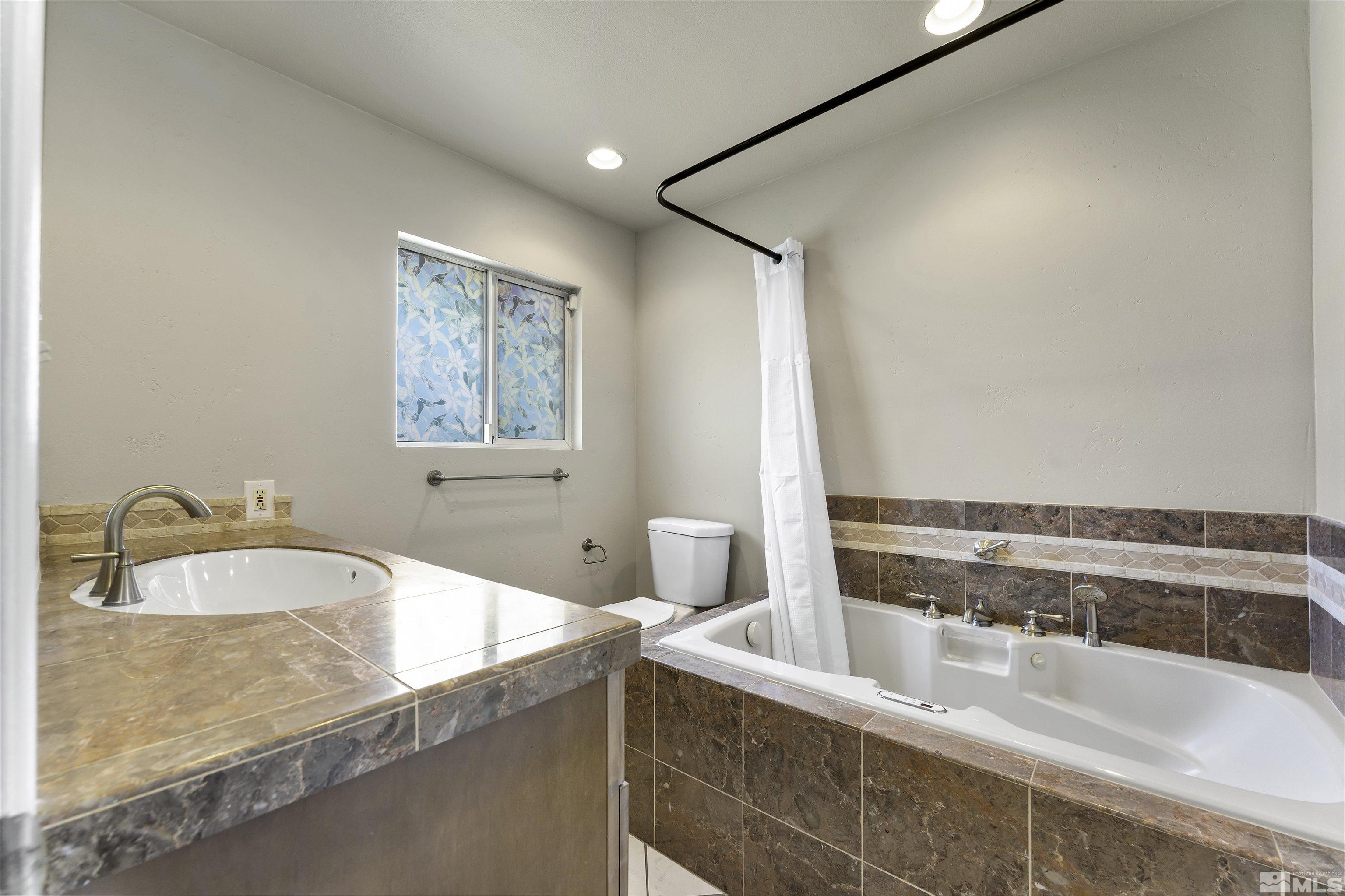 1401 Romero Way Reno, NV 89509 - Photo 18 of 28 a bathroom with a granite countertop sink and a bathtub