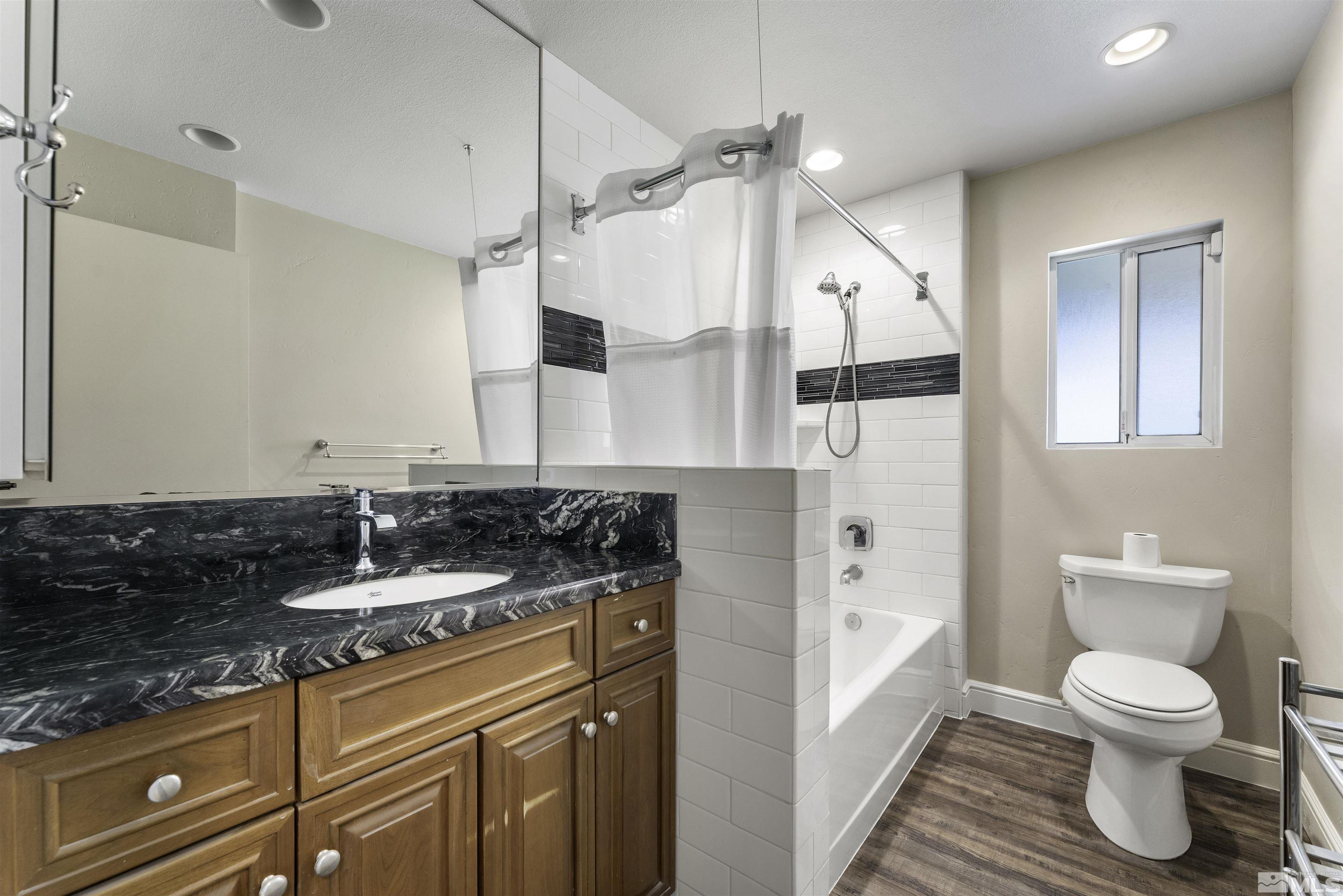 1401 Romero Way Reno, NV 89509 - Photo 21 of 28 a spacious bathroom with a granite countertop sink a toilet and a shower